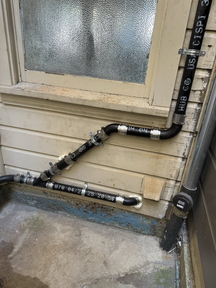 Black steel gas line installation with CSST fittings on exterior wall